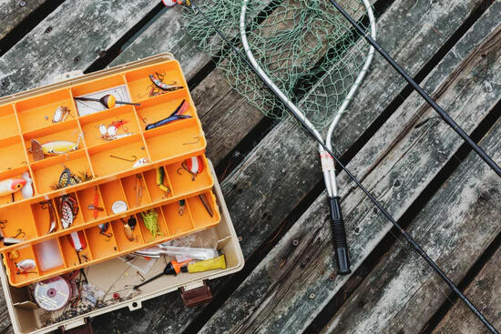 A box of fishing flies and a landing net