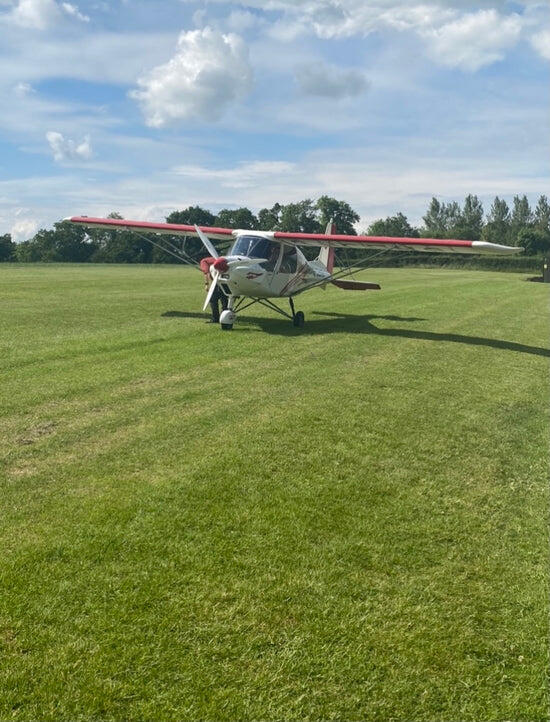 A light aircraft on a grass airfield